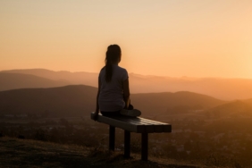 Sakin bir ortamda bağdaş kurup meditasyon yapan kişi