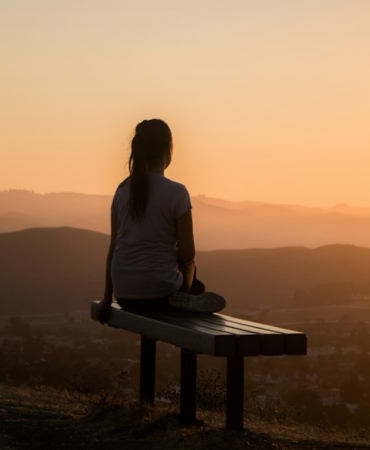 Sakin bir ortamda bağdaş kurup meditasyon yapan kişi